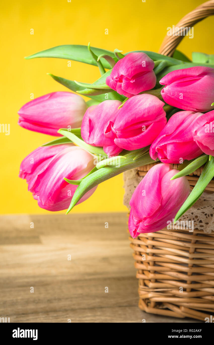 Beau bouquet de tulipes roses dans un panier en osier Banque D'Images