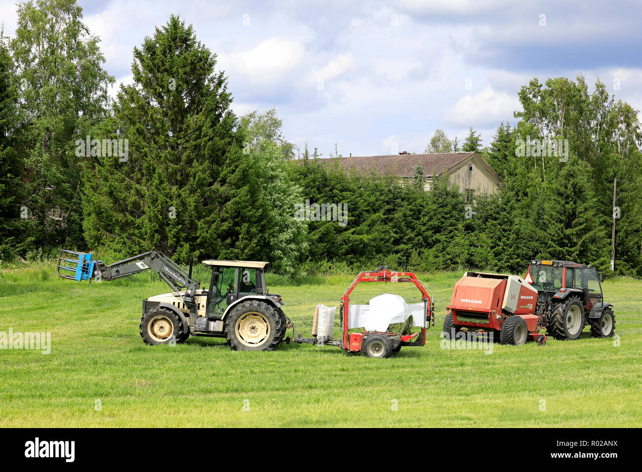 Uurainen, Finlande - le 15 juin 2018 : Wrapping hay bales in plastic film avec Lamborghini tracteur tiré Vicon BV 1700 wrapper par satellite sur jour de l'été Banque D'Images