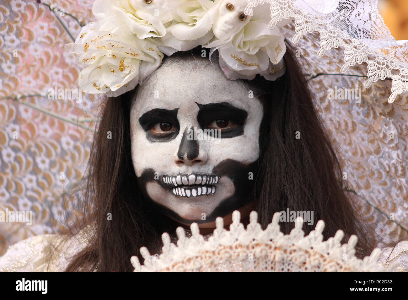 Jeune fille avec le joli crâne en sucre (Catrina) un miroir à jour des Morts (Dia de los Muertos) célébration Banque D'Images