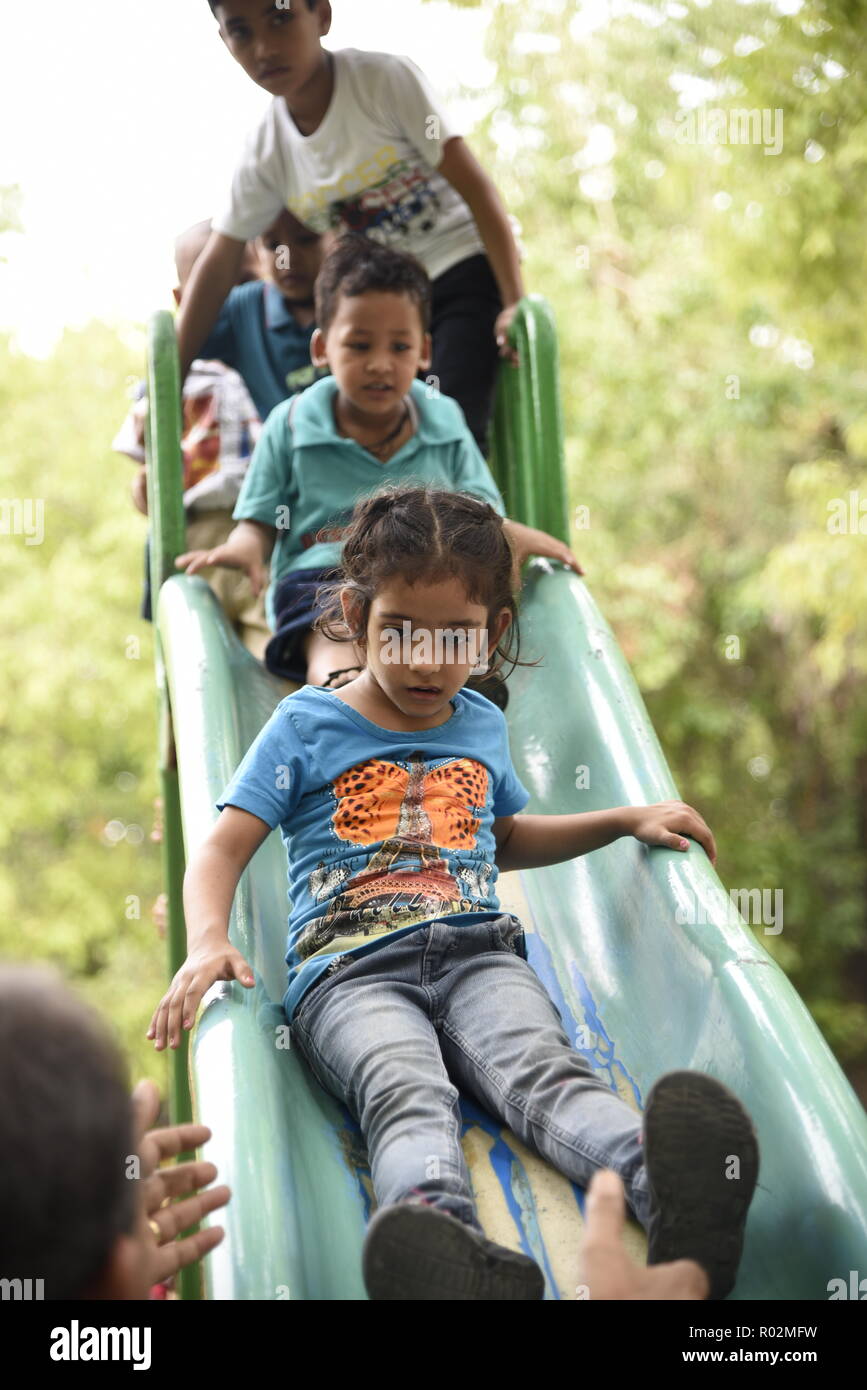 Cute smiling kids enjoying jouer avec le temps de l'humeur ludique dans un parc d'attractions ou d'enfants Park à New Delhi, Inde, Asie Banque D'Images