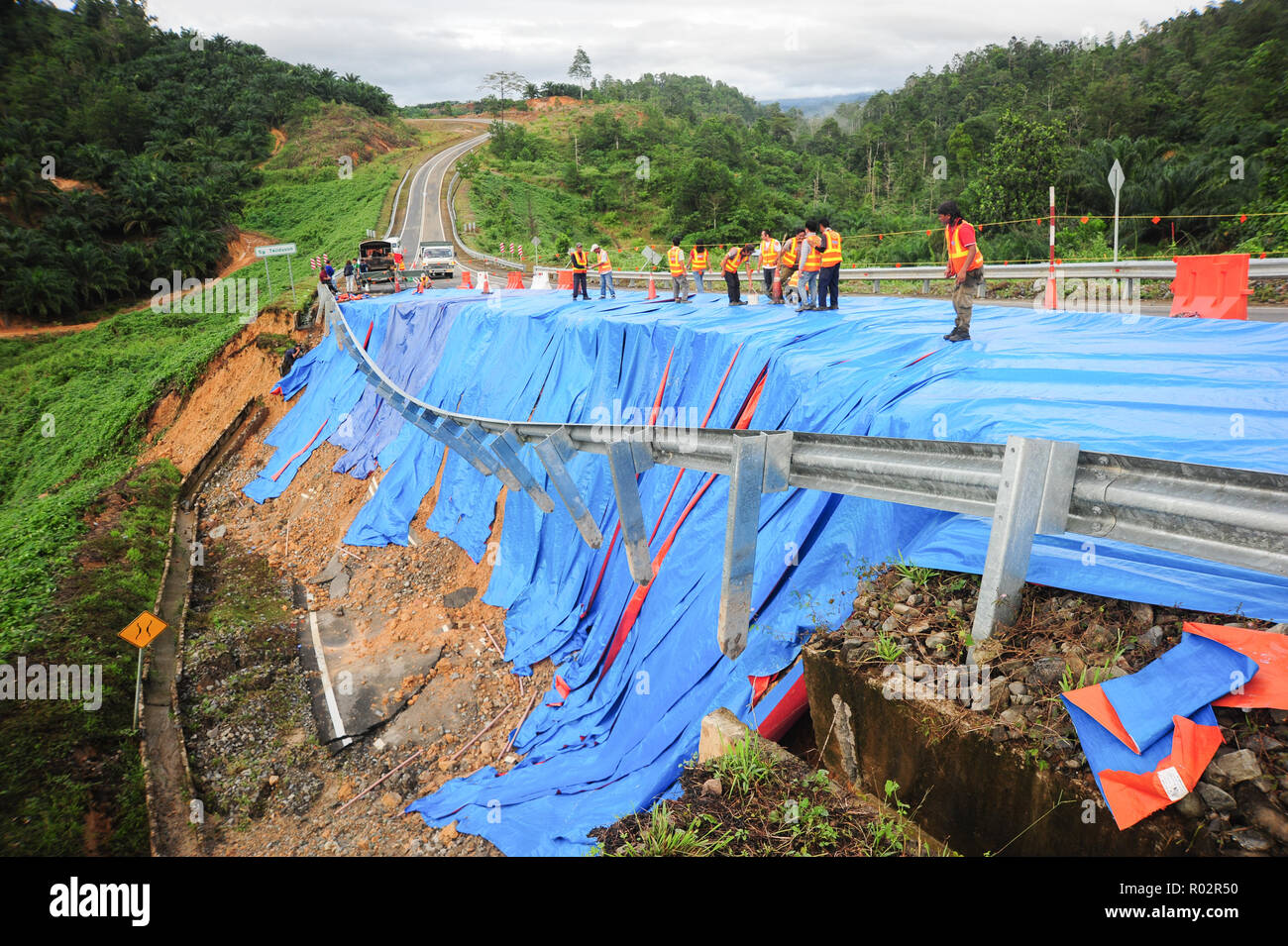 Kota Marudu Sabah Malaisie - 12 Jan 2018 : couvrant les travailleurs routiers endommagés avec toile d'éviter plus d'errosion. Le glissement de terrain au chemin rural est due à il Banque D'Images