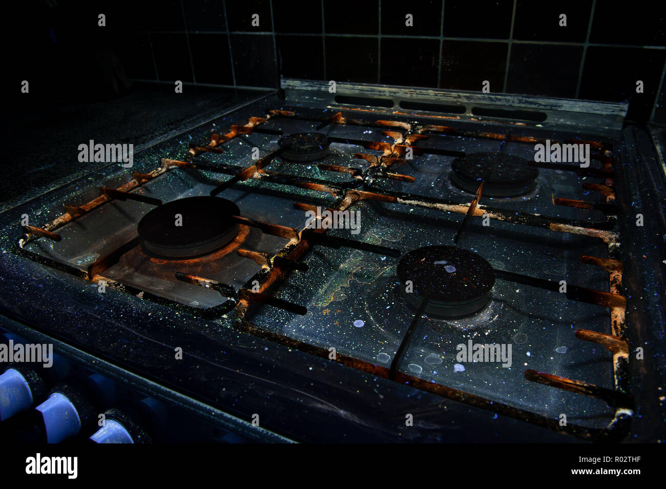 Qui, à première vue, une cuisinière à gaz révèle la saleté, huile, graisse, éclaboussé de cires grasses, les bactéries qui brillent sous la lumière UV montrant les pratiques d'hygiène Banque D'Images