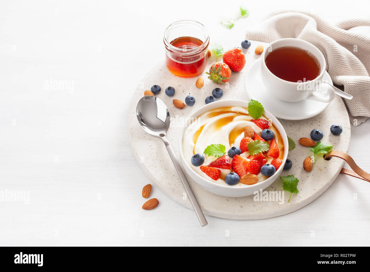 Du yaourt au miel et aux amandes myrtille fraise pour le petit déjeuner Banque D'Images