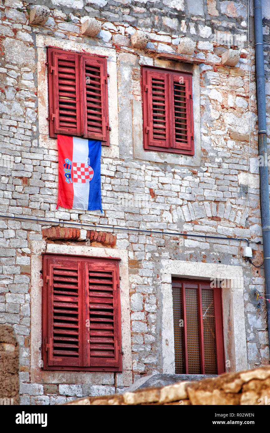 Drapeau croate sous une fenêtre aux volets rouges dans la région de Sibenik Croatie. Banque D'Images