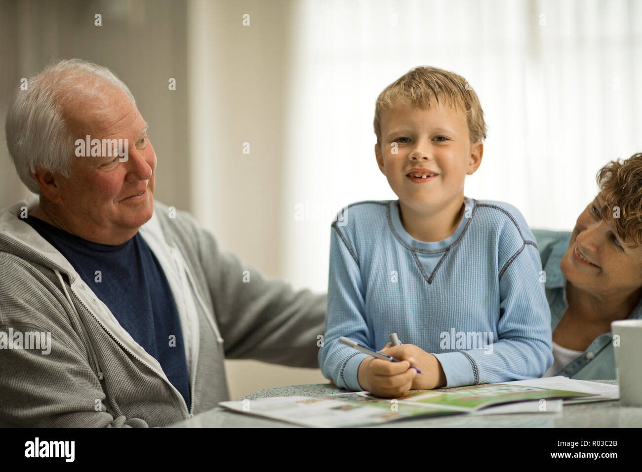 Portrait of smiling Young boy sitting avec ses grands-parents. Banque D'Images