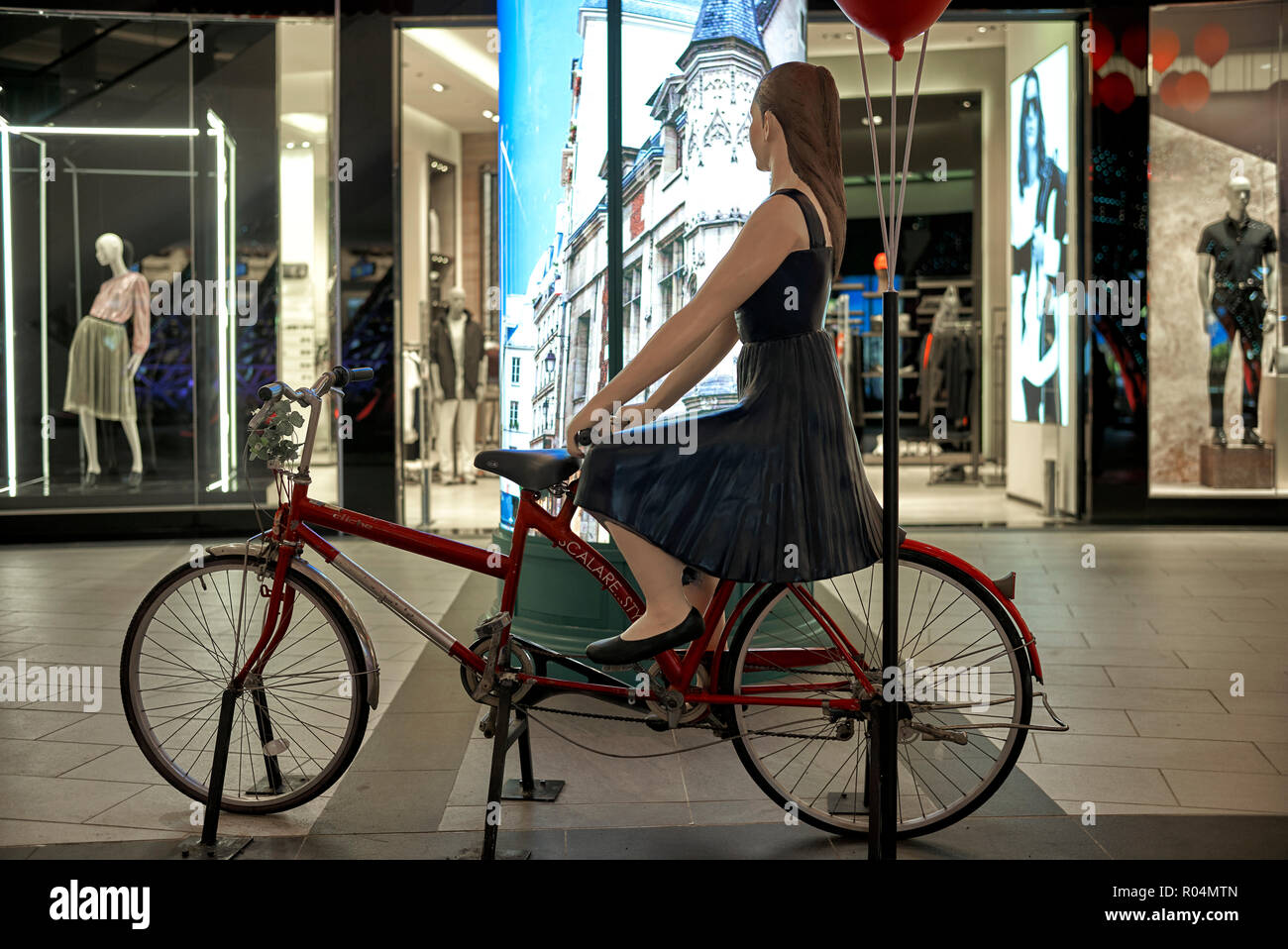 Statue. Statue de femme amusant de rouler à vélo et faire du lèche-vitrine. dans un centre commercial de la Thaïlande. Banque D'Images