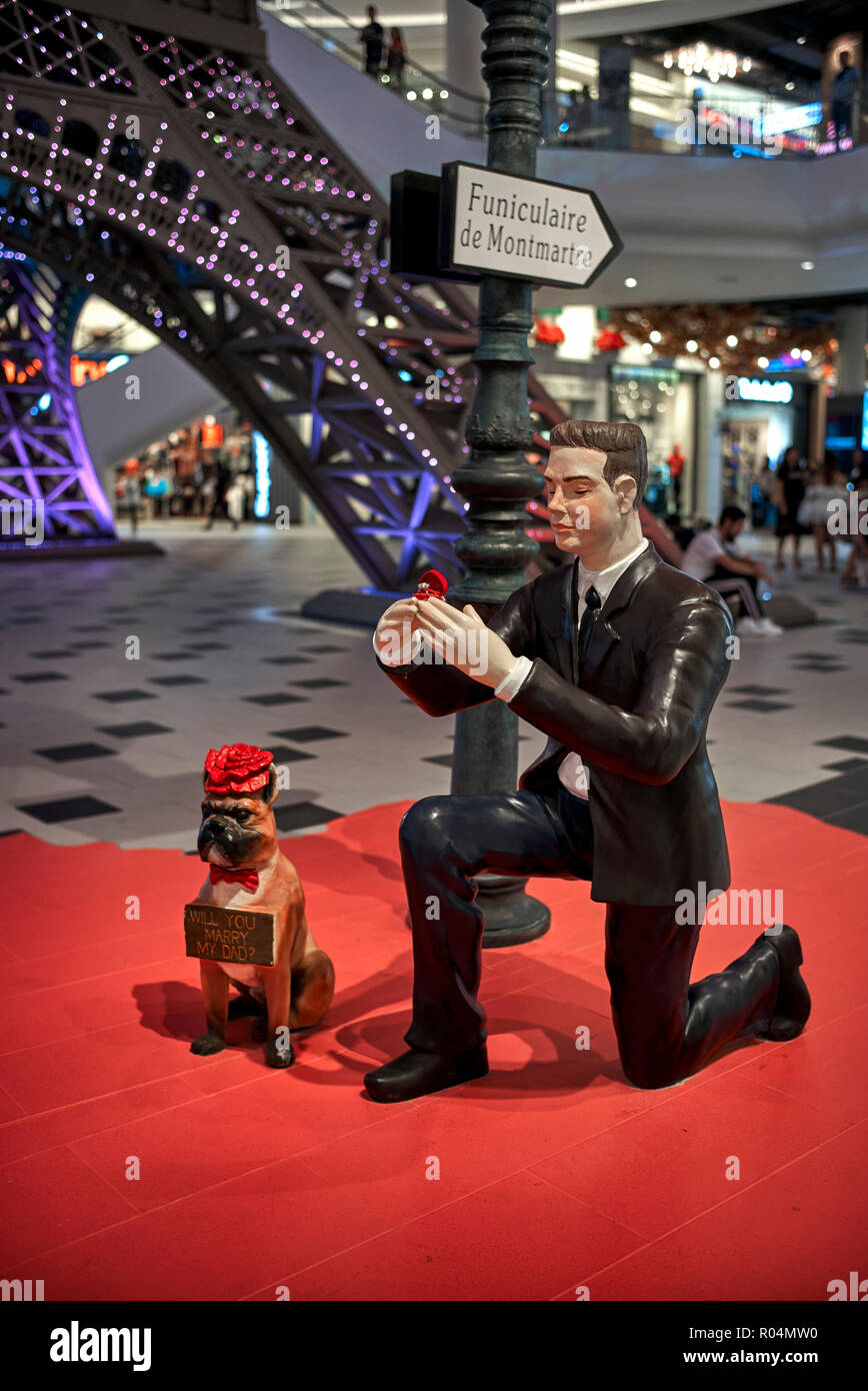 Statue. Statue amusante dans un centre commercial de la Thaïlande d'un homme à genoux proposant le mariage avec le chien portant un signe approprié Banque D'Images