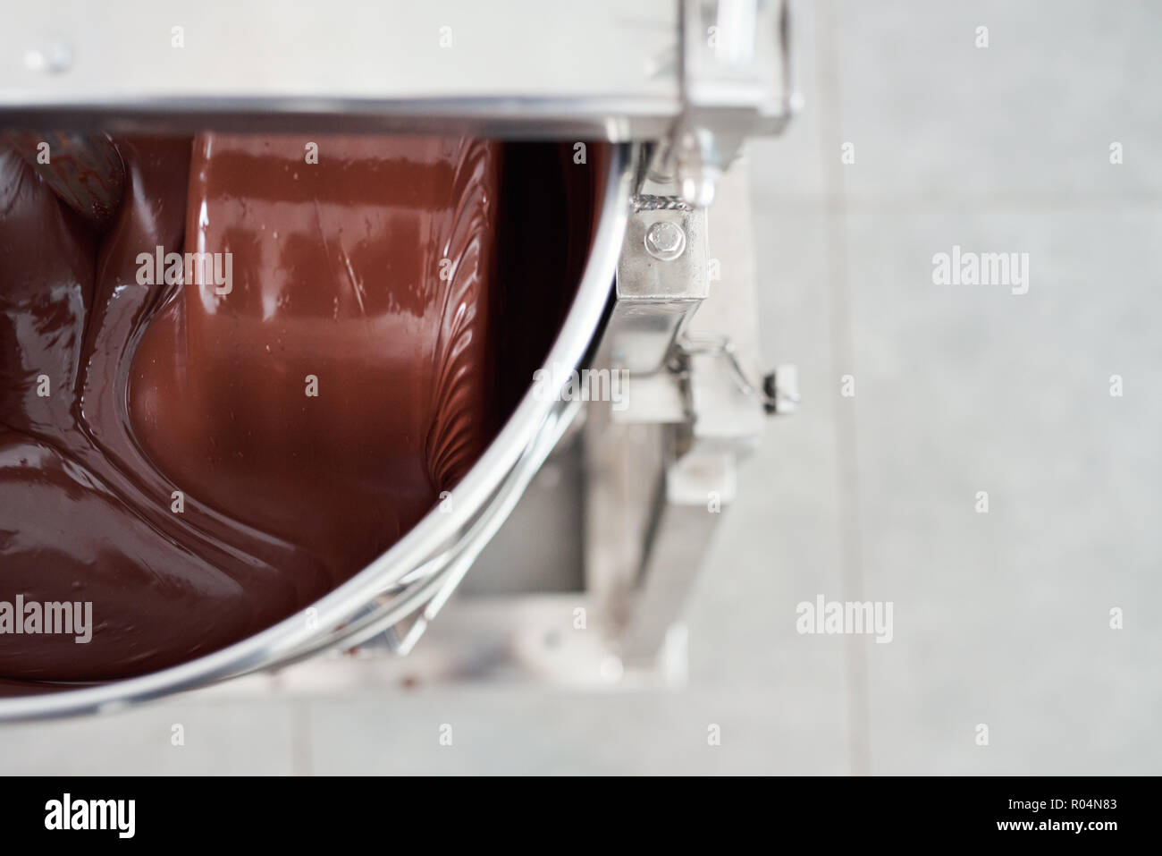 Le chocolat fondu d'être remué dans un mélangeur en acier inoxydable Banque D'Images