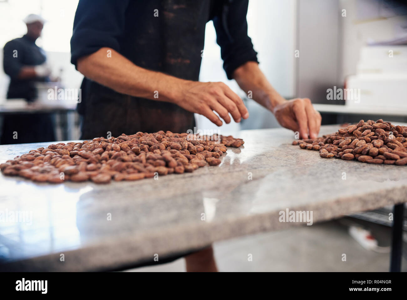 Fabrique de chocolat fèves de cacao Examen de la main du travailleur Banque D'Images