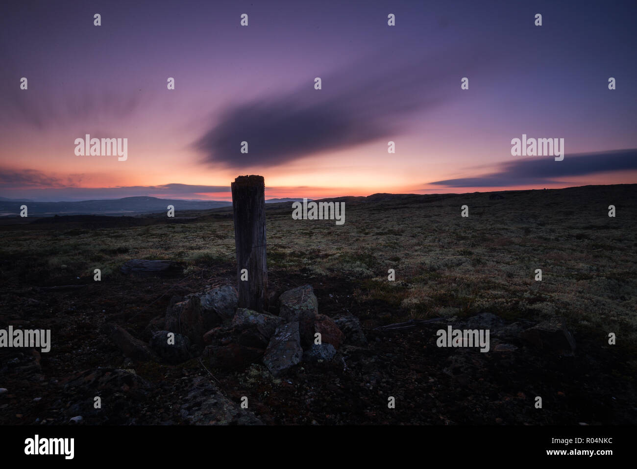 Une longue exposition sur ciel nocturne et les paysages de la zone d'Nordgruvefeltet au milieu de la Norvège. Poteau en bois dans le sol. Banque D'Images