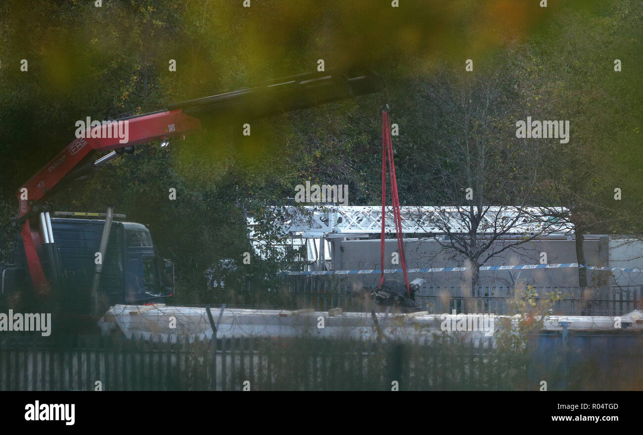 Une grue se déplace une partie de l'épave de l'hélicoptère survenu à Leicester City Football Club. Banque D'Images