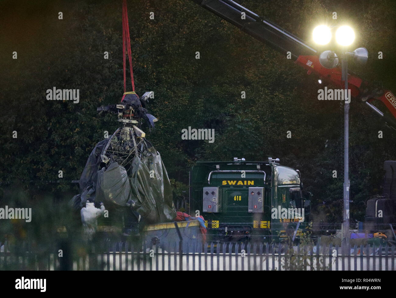 Une grue se déplace une partie de l'épave de l'hélicoptère survenu à Leicester City Football Club. Banque D'Images