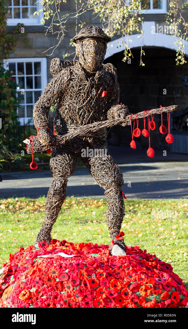 Great Ayton, village, North Yorkshire, Angleterre, Royaume-Uni. 2 novembre 2018. Coquelicots tricoté autour de Willow sculpture de soldat de la Première Guerre mondiale. Banque D'Images