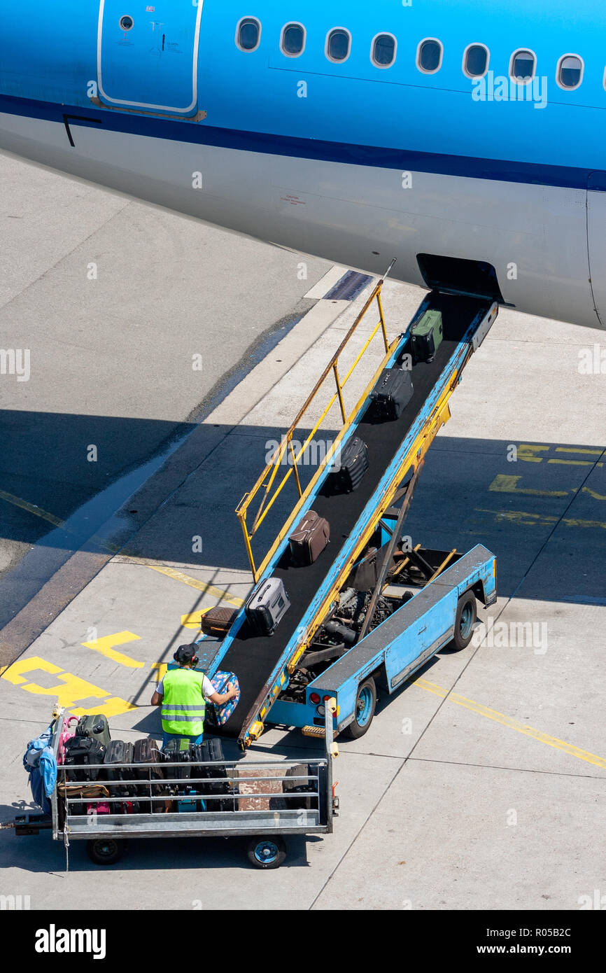 Aéroport le bagagiste placez des bagages sur un tapis roulant à l'avion  Photo Stock - Alamy