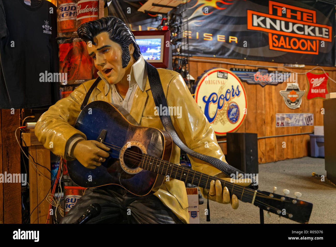 STURGIS, DAKOTA DU SUD, le 18 septembre 2018 : une statue d'Elvis Presley semble jouer à la guitare dans un saloon de la ville, avec beaucoup d'enseignes publicitaire à t Banque D'Images