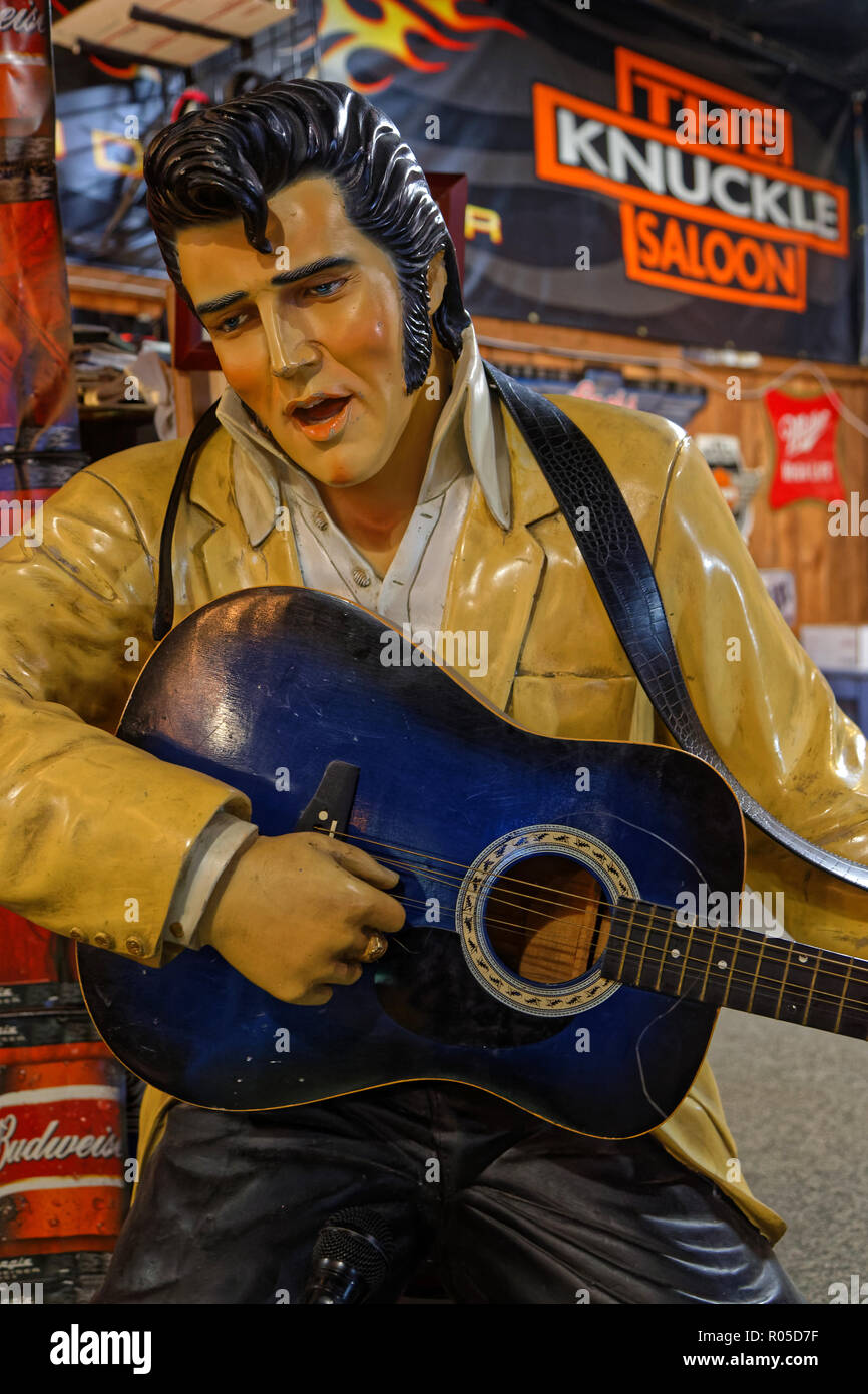 STURGIS, DAKOTA DU SUD, le 18 septembre 2018 : une statue d'Elvis Presley semble jouer à la guitare dans un saloon de la ville, avec beaucoup d'enseignes publicitaire à t Banque D'Images
