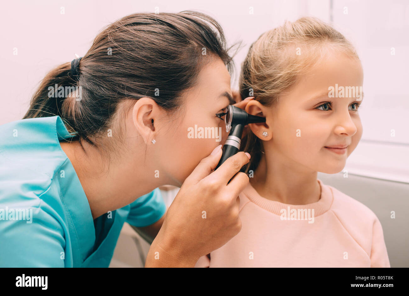 Médecin vérifier une fille avec les oreilles d'un otoscope Banque D'Images
