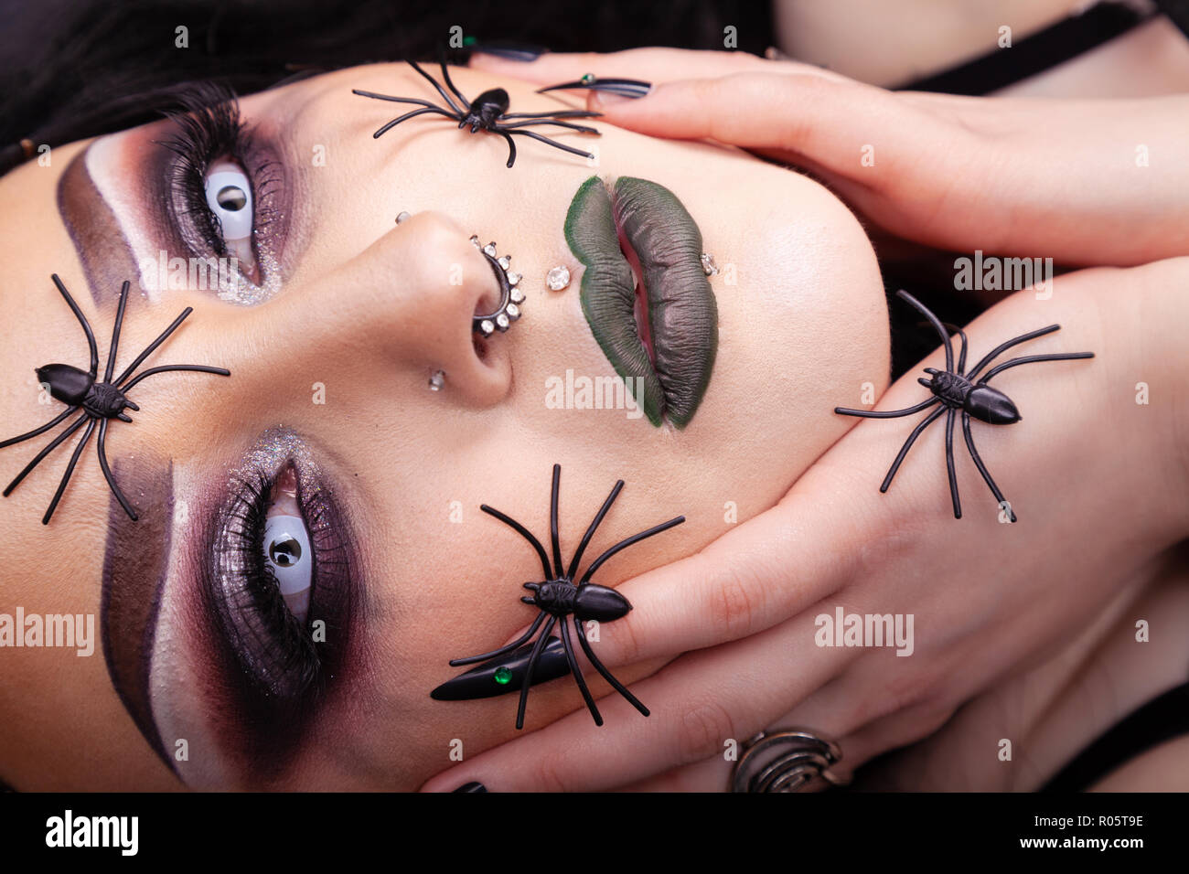 Close up of a woman's face à la gothique avec de fausses araignées en plastique. Banque D'Images