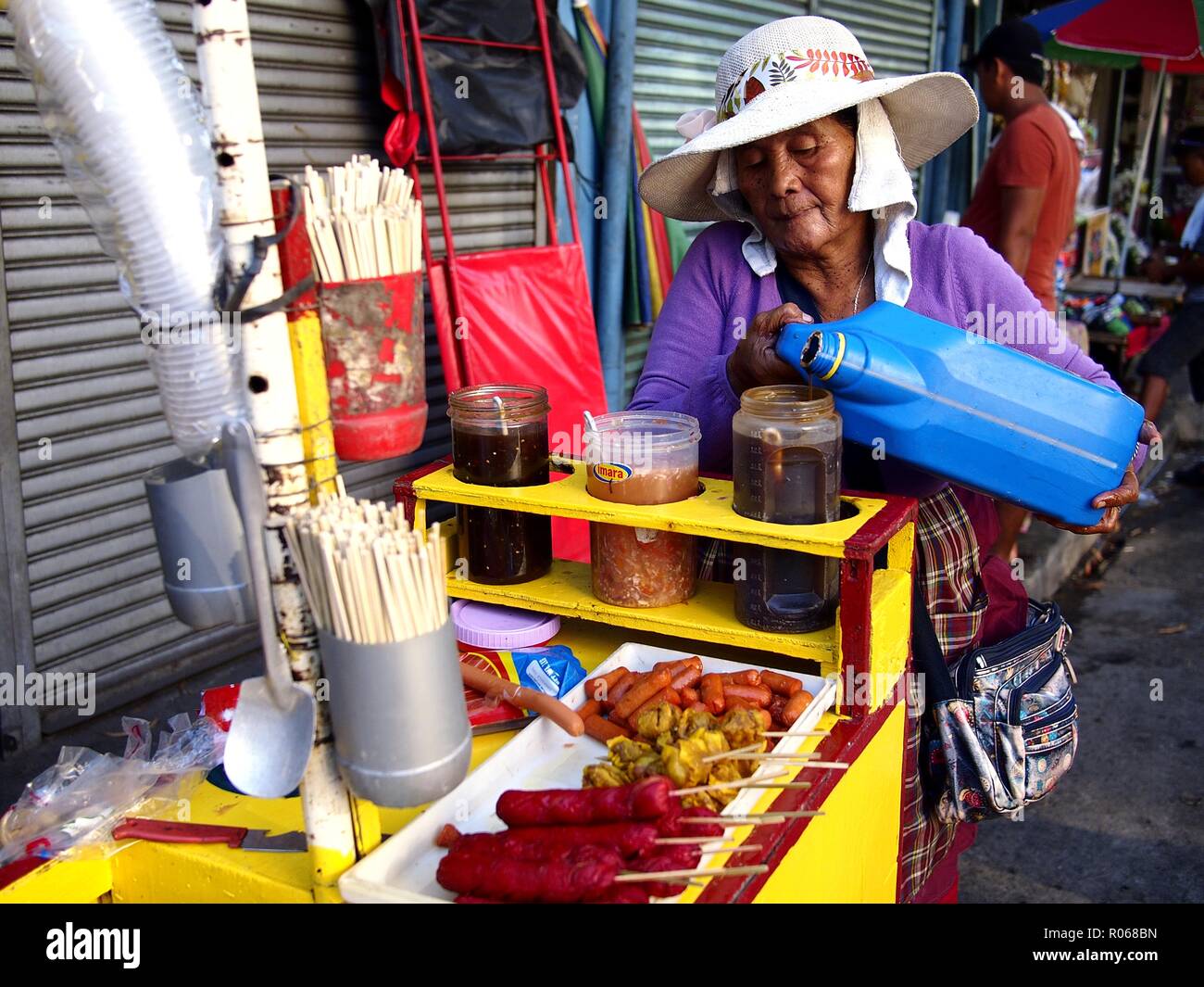 ANTIPOLO CITY, PHILIPPINES - 31 octobre 2018 : un homme vend un assortiment de délicieux aliments frits sur son panier alimentaire à un trottoir. Banque D'Images