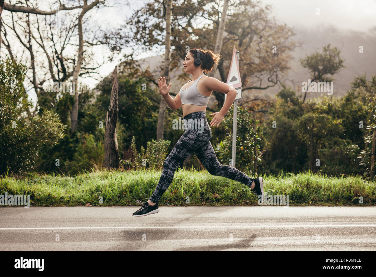 Portrait de femme côté sprint en plein air sur la route. Femme dans les vêtements de sport en plein air dans l'exécution de matin. Banque D'Images