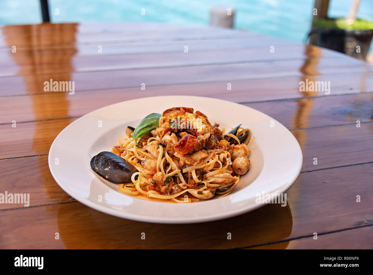 Pâtes aux fruits de mer en bol blanc sur la table en bois Banque D'Images