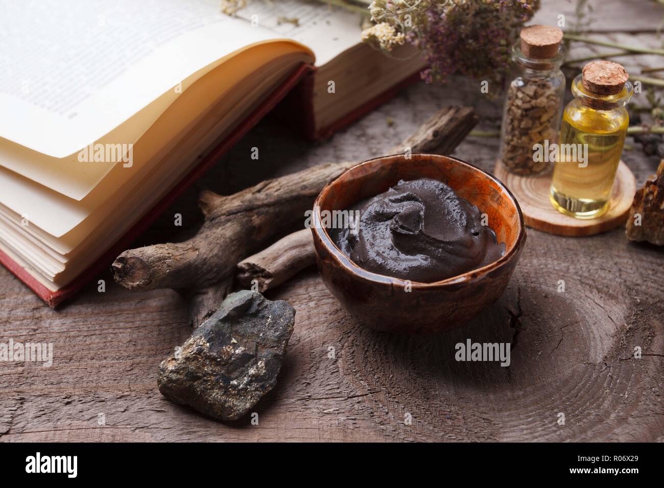 Masque de boue noire cosmétique préparation dans un bol en céramique vintage sur fond de bois. Libre de texture de l'argile du visage émulsion. Les cosmétiques naturels pour la maison ou Banque D'Images