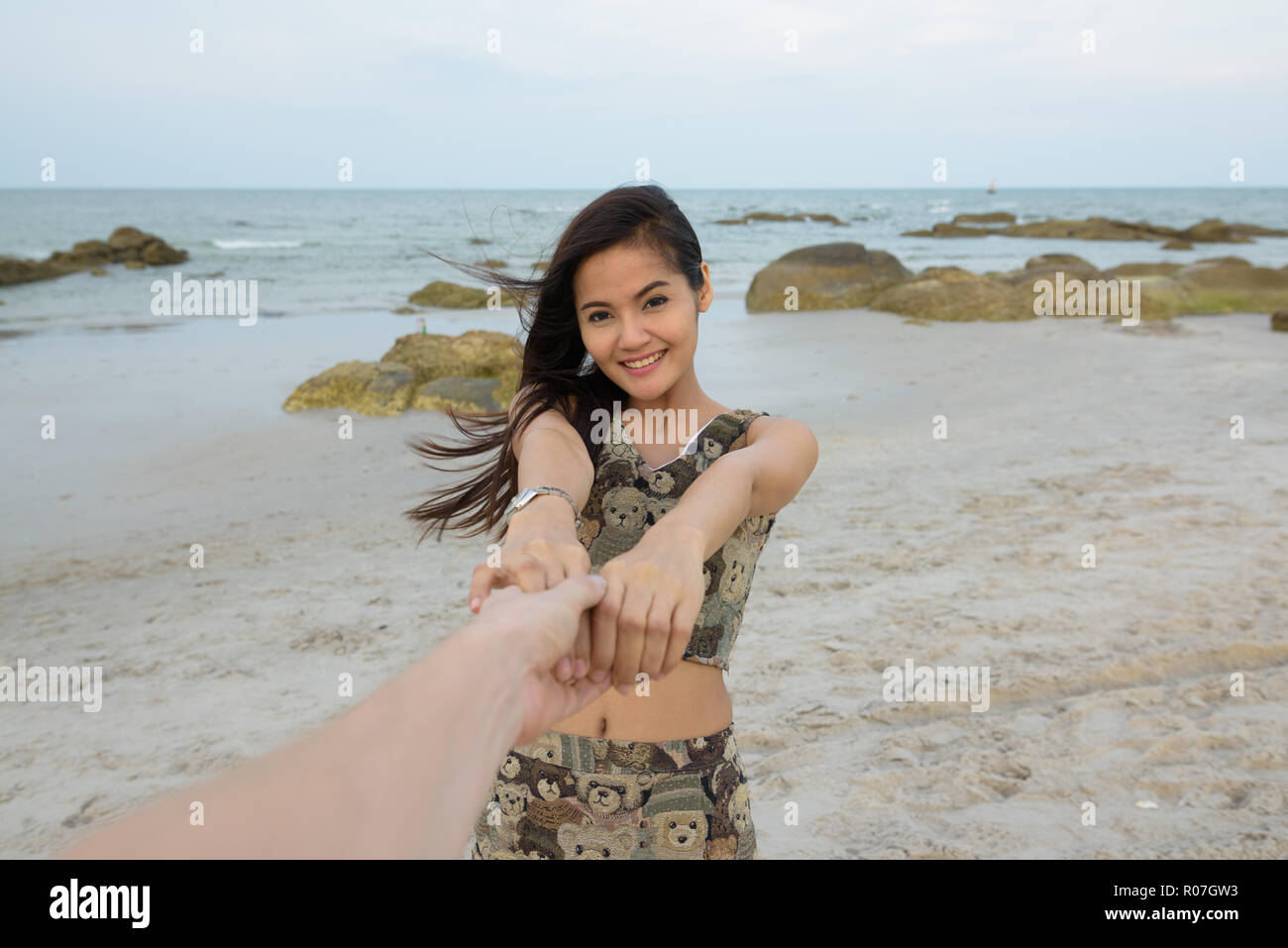 Young happy Asian woman smiling while holding avec bot Banque D'Images