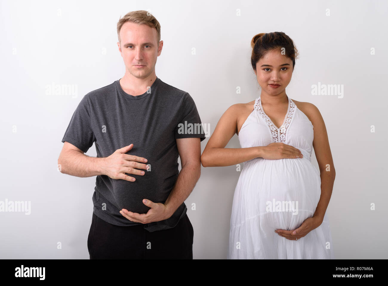 Couple holding leur estomac car ils tous les deux serait enceinte Banque D'Images