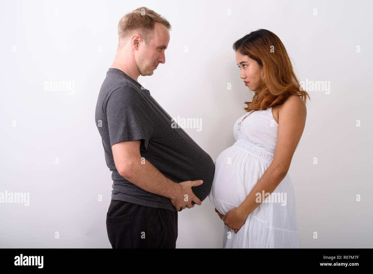 Couple holding leur estomac car ils tous les deux serait enceinte Banque D'Images
