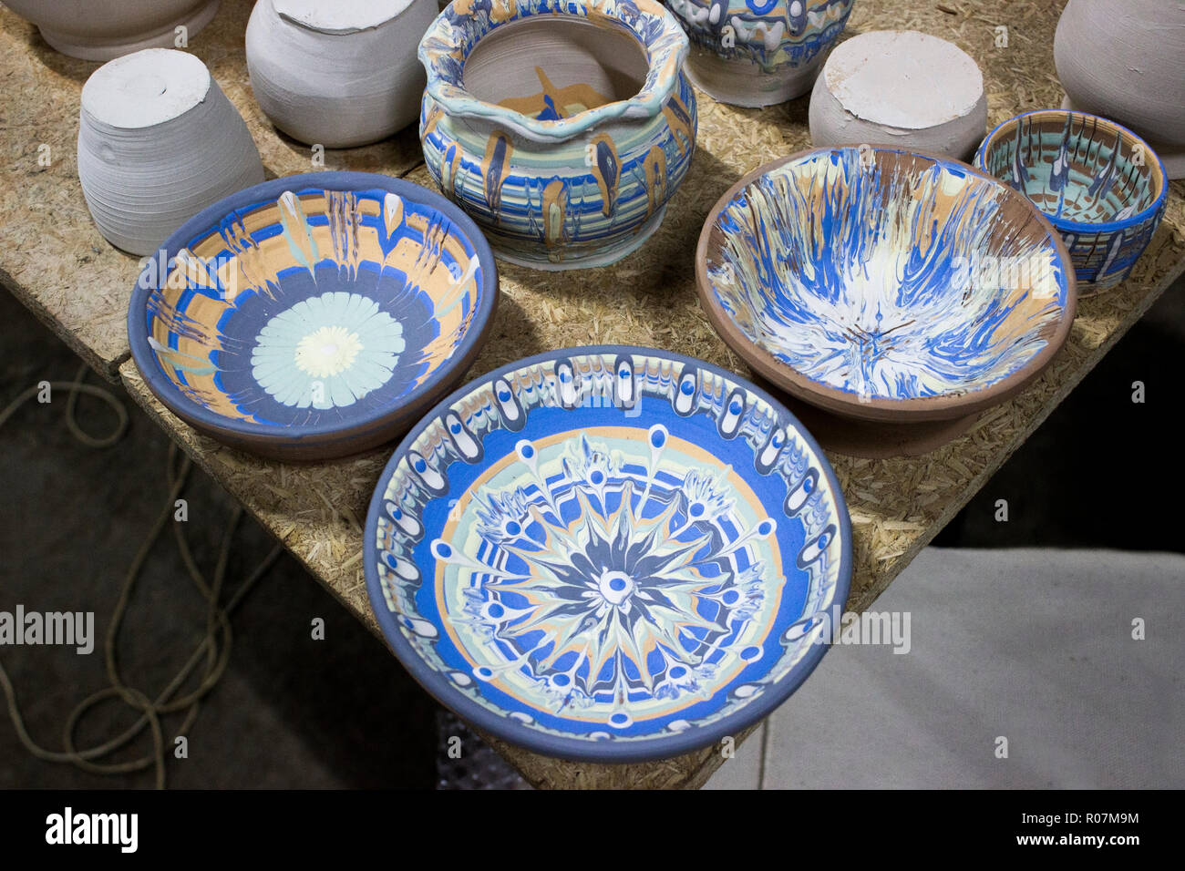 Vaisselle peinte avec un engobe est mélangé avec des pigments colorés sur une poterie vacances avec la participation d'un artisan bulgare avec 1 Banque D'Images