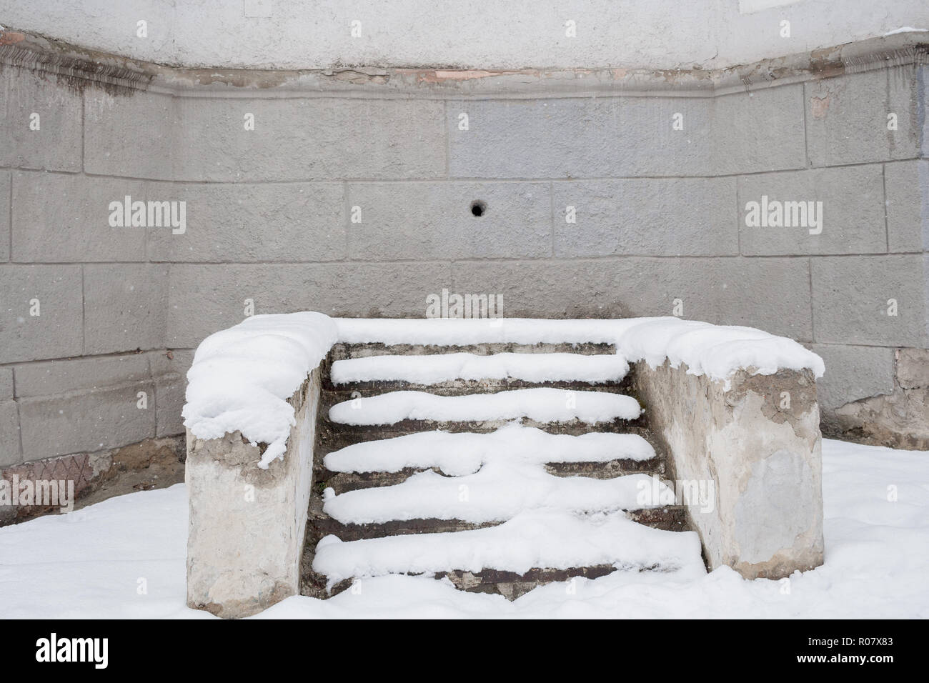 Escalier en pierre couverte de neige près de mur de l'ancien bâtiment gris avec Banque D'Images