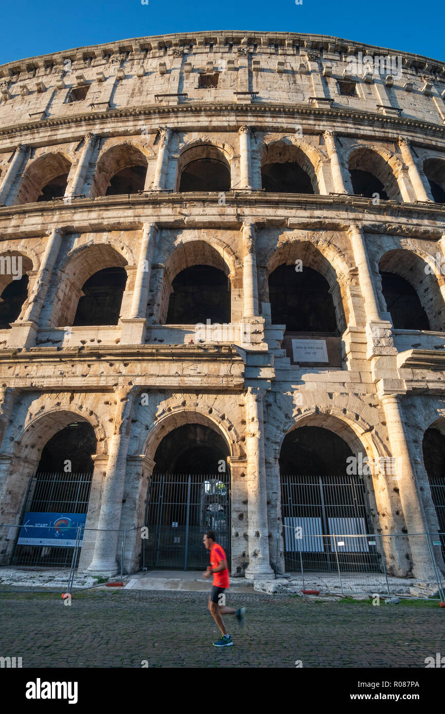 Un matin tôt jogger passe devant le Colisée dans le centre de Rome, Italie. Banque D'Images