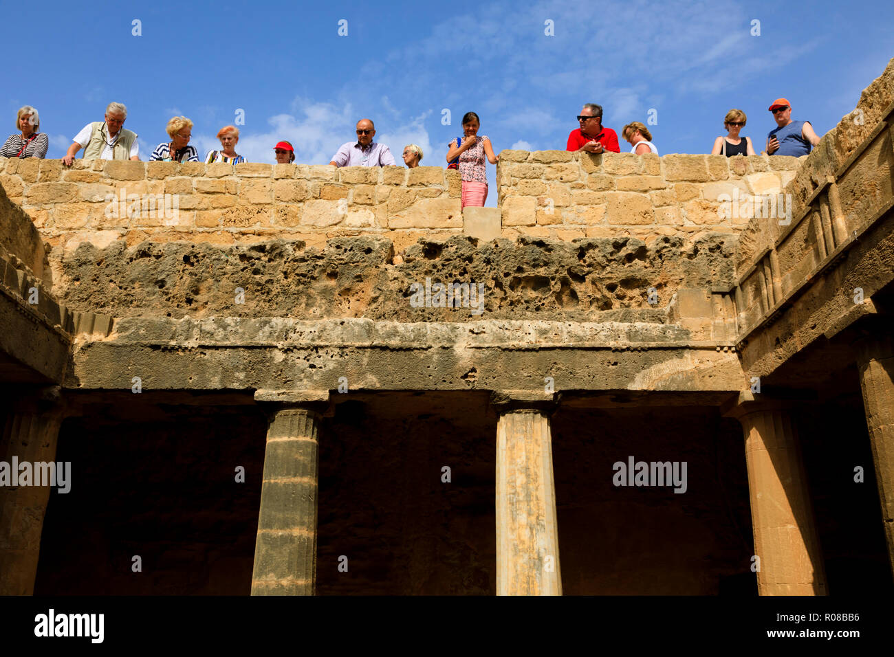 Les touristes se pencher sur l'un des tombeaux ouverts au Tombeau des rois, les Tombeaux des Rois, Paphos, Chypre Octobre 2018 Banque D'Images