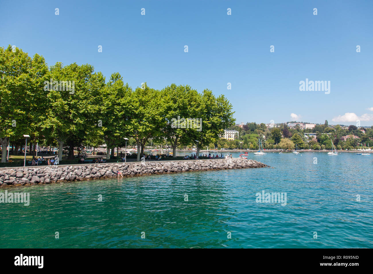 Vue front de mer de la zone d'Ouchy à Lausanne, ville de Suisse sur le Lac Léman (Lac de Genève) le jour d'été ensoleillé avec ciel bleu et nuages blancs Banque D'Images