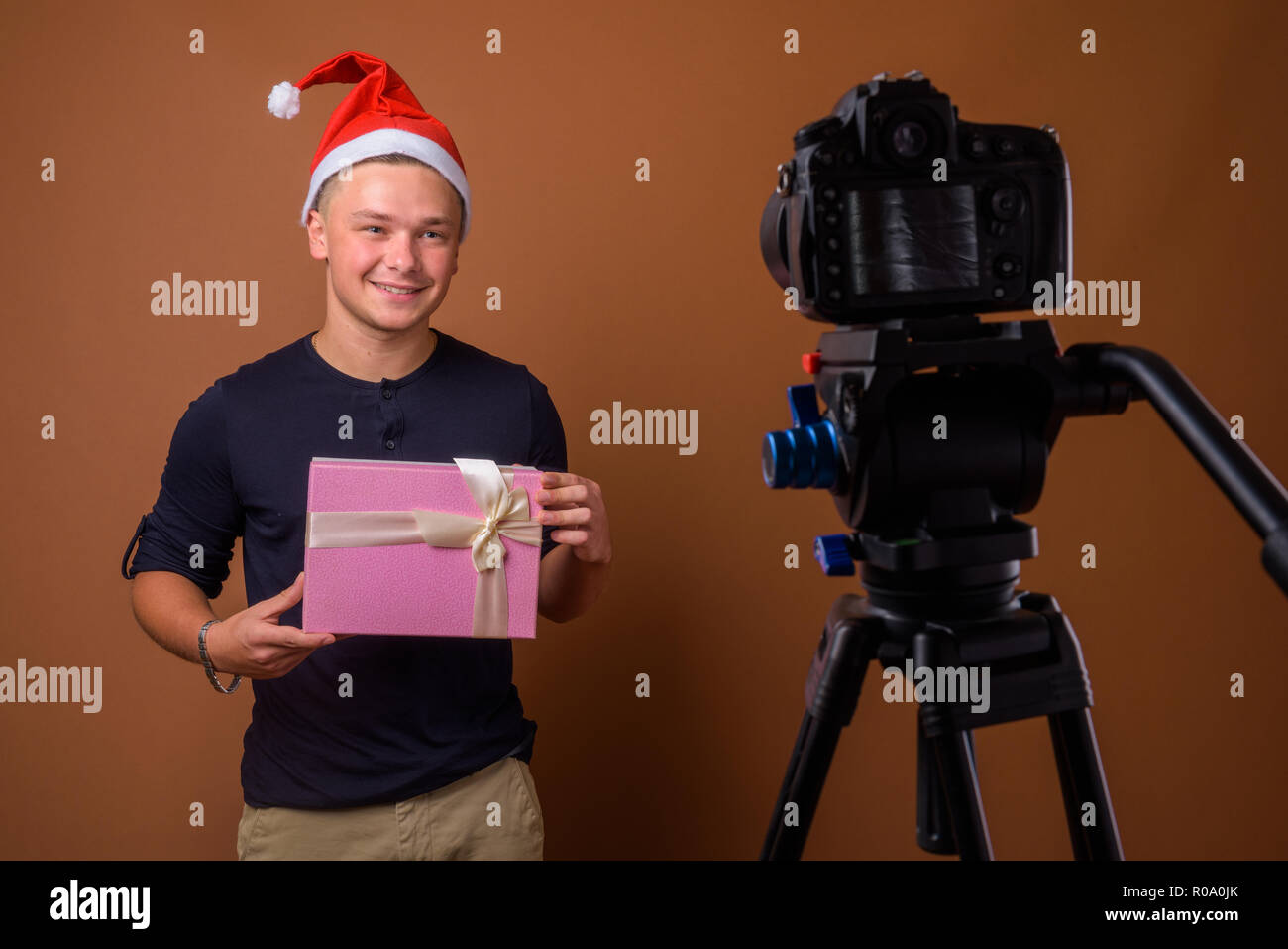 Portrait de jeune homme séduisant contre fond brun Banque D'Images
