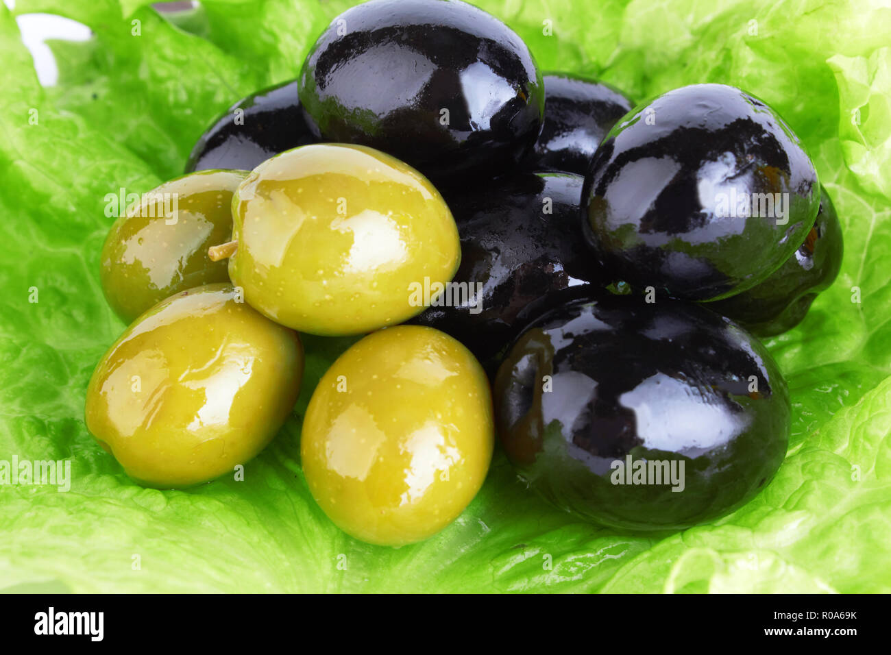 Olives vertes et noires sur feuille de salade verte Banque D'Images
