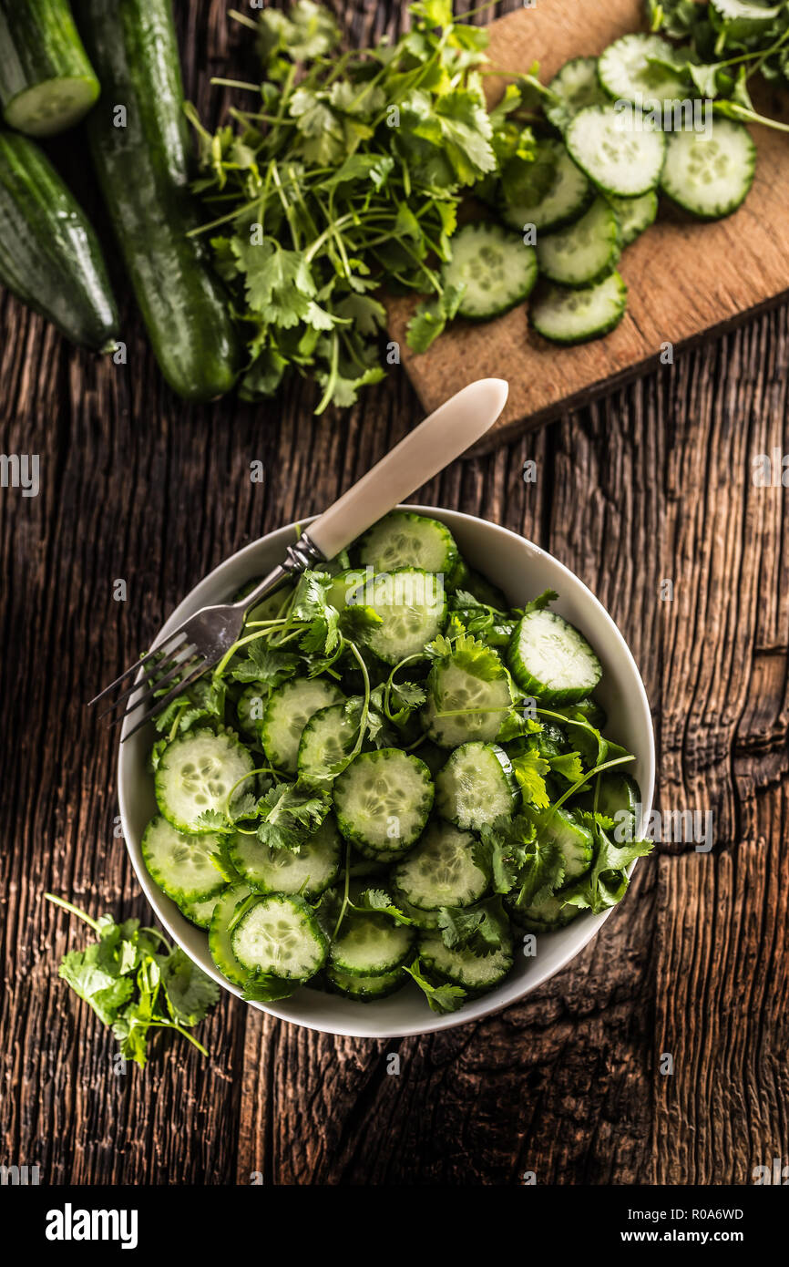 Tranches de concombre sur une assiette avec le persil herb sur bois Chêne rustique. Banque D'Images