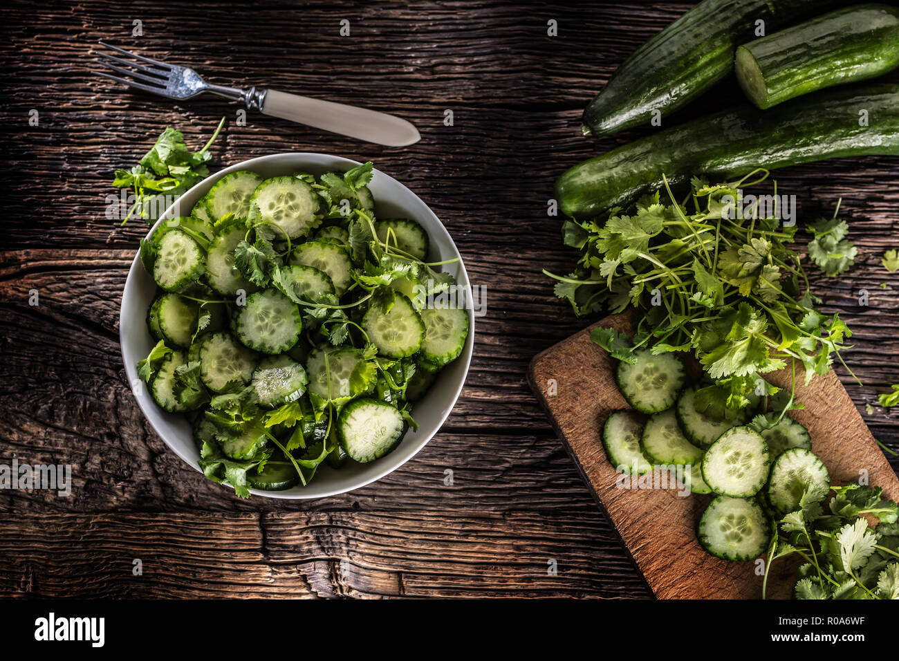 Tranches de concombre sur une assiette avec le persil herb sur bois Chêne rustique. Banque D'Images