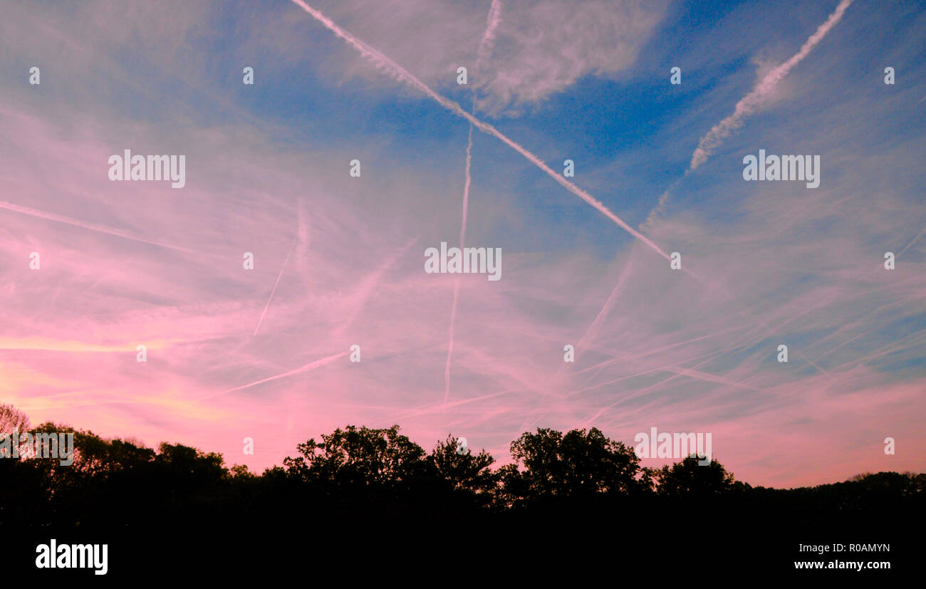 Contrail, également appelée traînée de condensation ou de vapeur, nuage de banderoles parfois observé derrière un avion volant dans l'air humide froid clair. Il forme à la condensation de vapeur d'eau produite par la combustion de carburant dans les moteurs d'avion. Lorsque l'humidité relative ambiante est élevée, le panache de cristaux de glace qui peuvent durer plusieurs heures. Le sentier peut être déformée par les vents, et parfois elle se propage vers l'extérieur pour former une couche de nuages cirrus. Ces ont été photographiés dans le sud de l'Angleterre en début de matinée. Banque D'Images