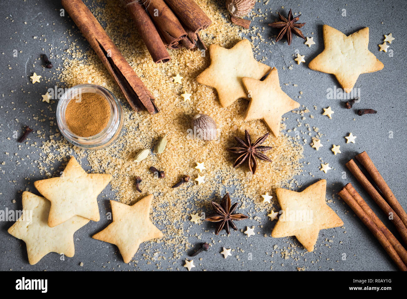 Épices de Noël, Christmas et ingrédients sur fond de béton gris. La cannelle, l'anis étoile, muscade, cardamome, clou de girofle, le sucre brun Banque D'Images