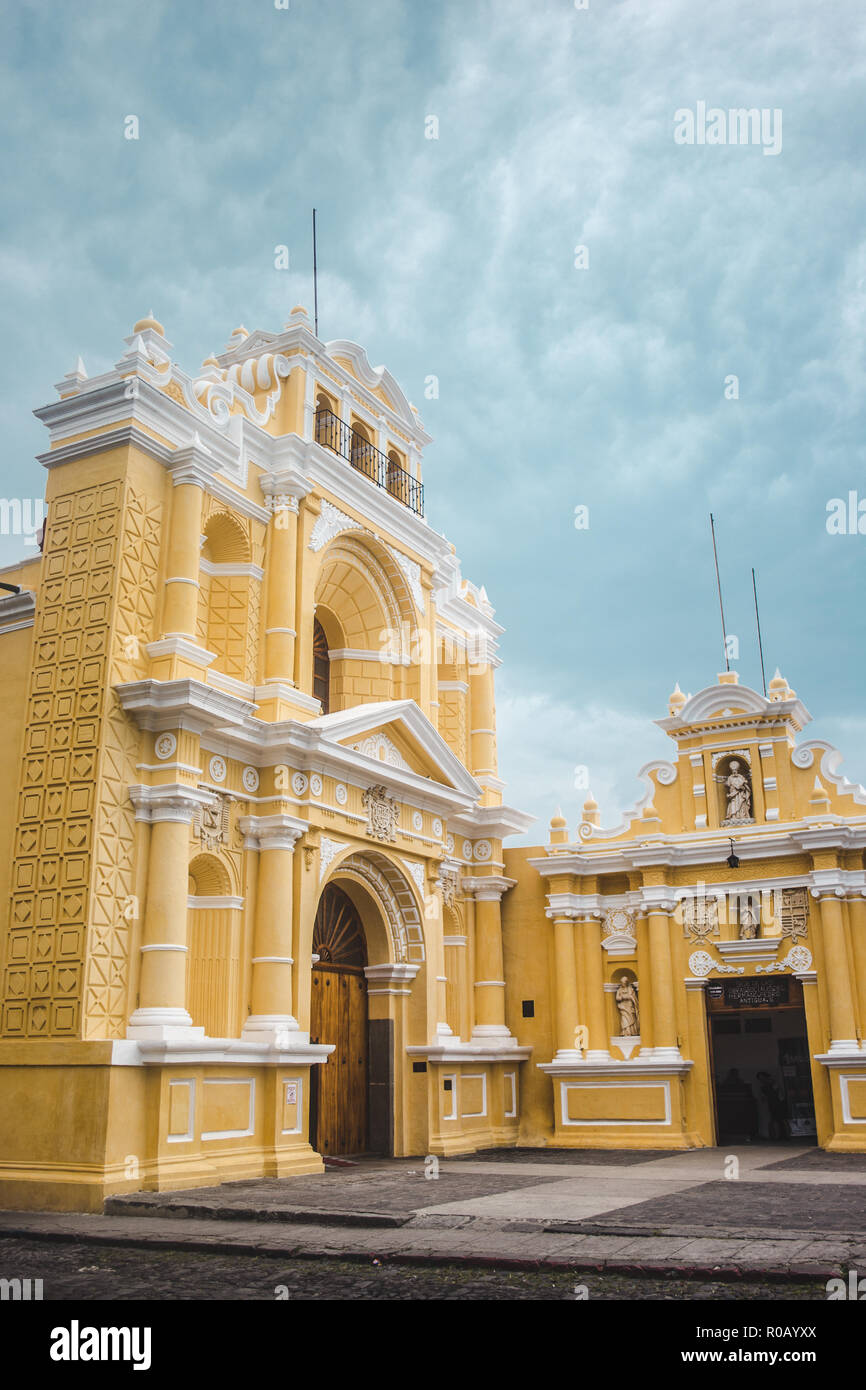 Monument jaune et blanche église catholique sur un jour nuageux dans Antigua Guatemala Banque D'Images