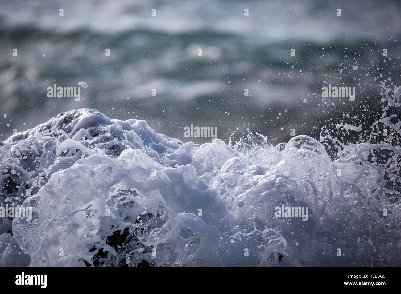 Mousseux blanc vagues se briser sur les rochers sur la côte Banque D'Images