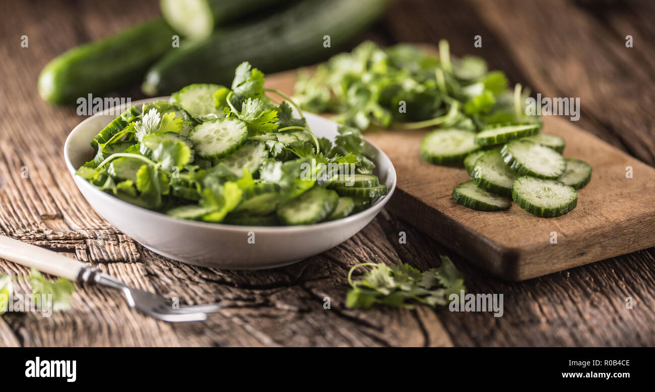 Tranches de concombre sur une assiette avec le persil herb sur bois Chêne rustique. Banque D'Images