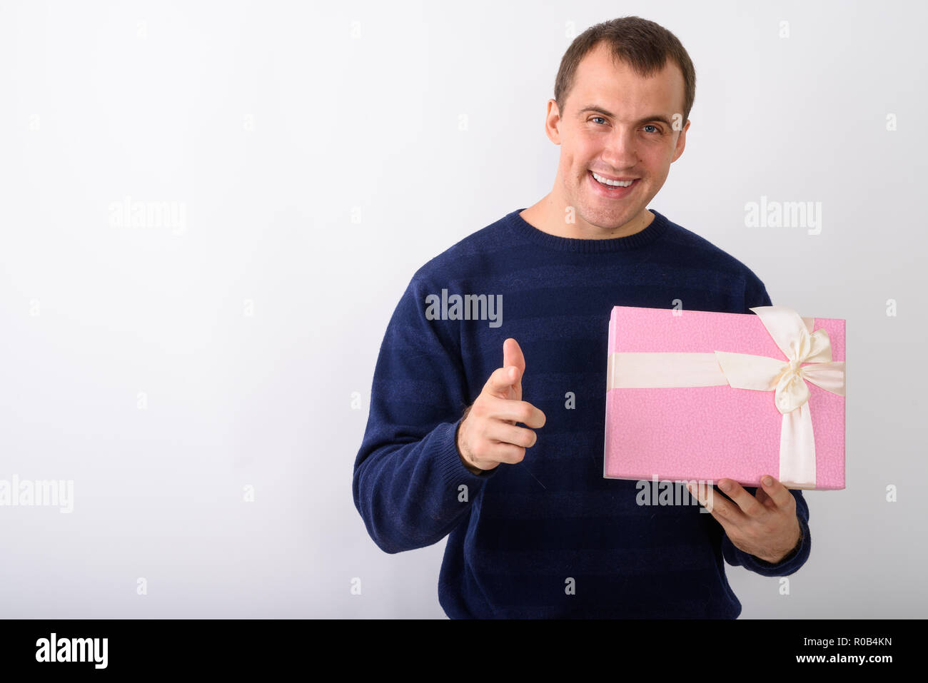 Studio shot of young happy man smiling musculaire tout en maintenant gi Banque D'Images