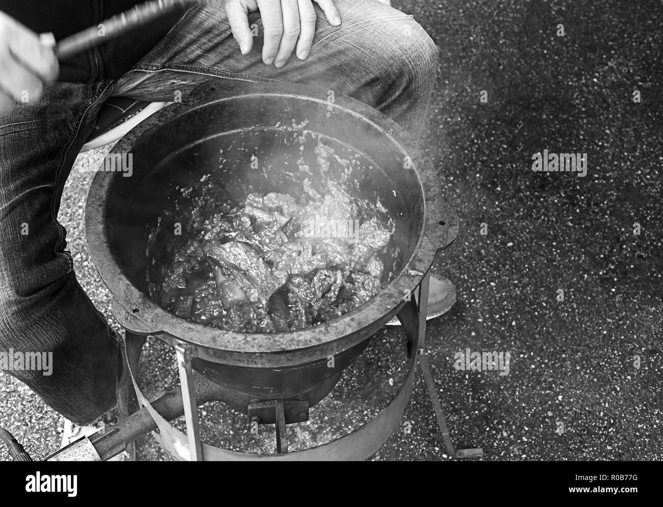 Personne n'est la cuisine du goulasch dans un grand pan de métal avec poêle à gaz. Banque D'Images