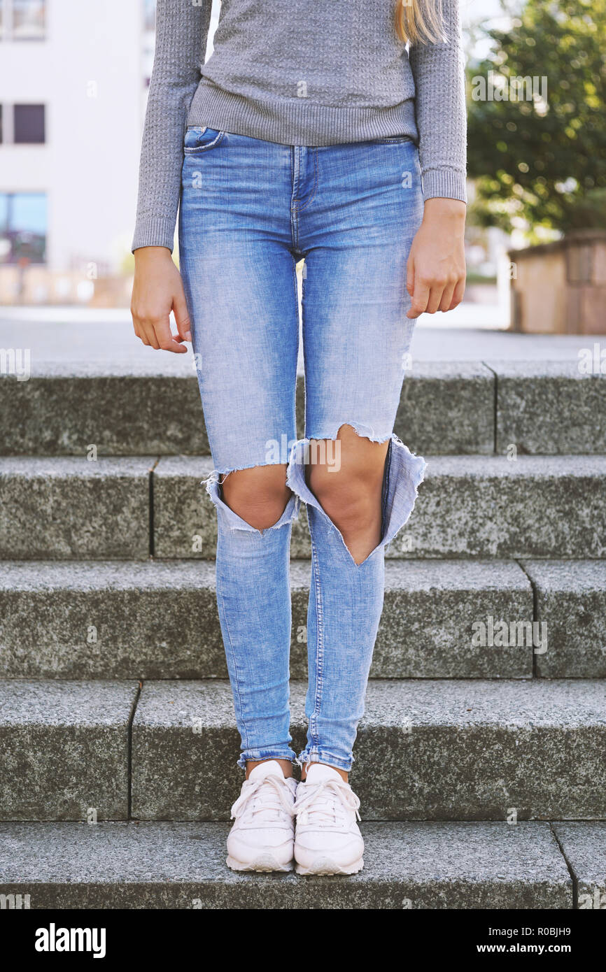 Distressed denim tendance de la mode, jeans déchirés avec des trous d'exposer les genoux de méconnaissable girl Banque D'Images