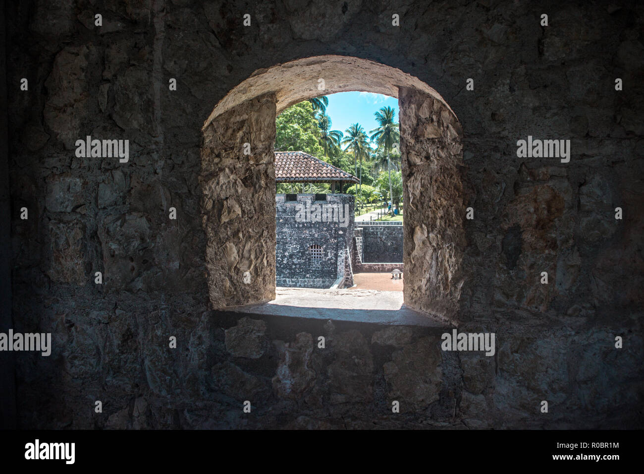 Regardant par la fenêtre en pierre du Castillo de San Felipe, un château à Rio Dulce, Guatemala est Banque D'Images