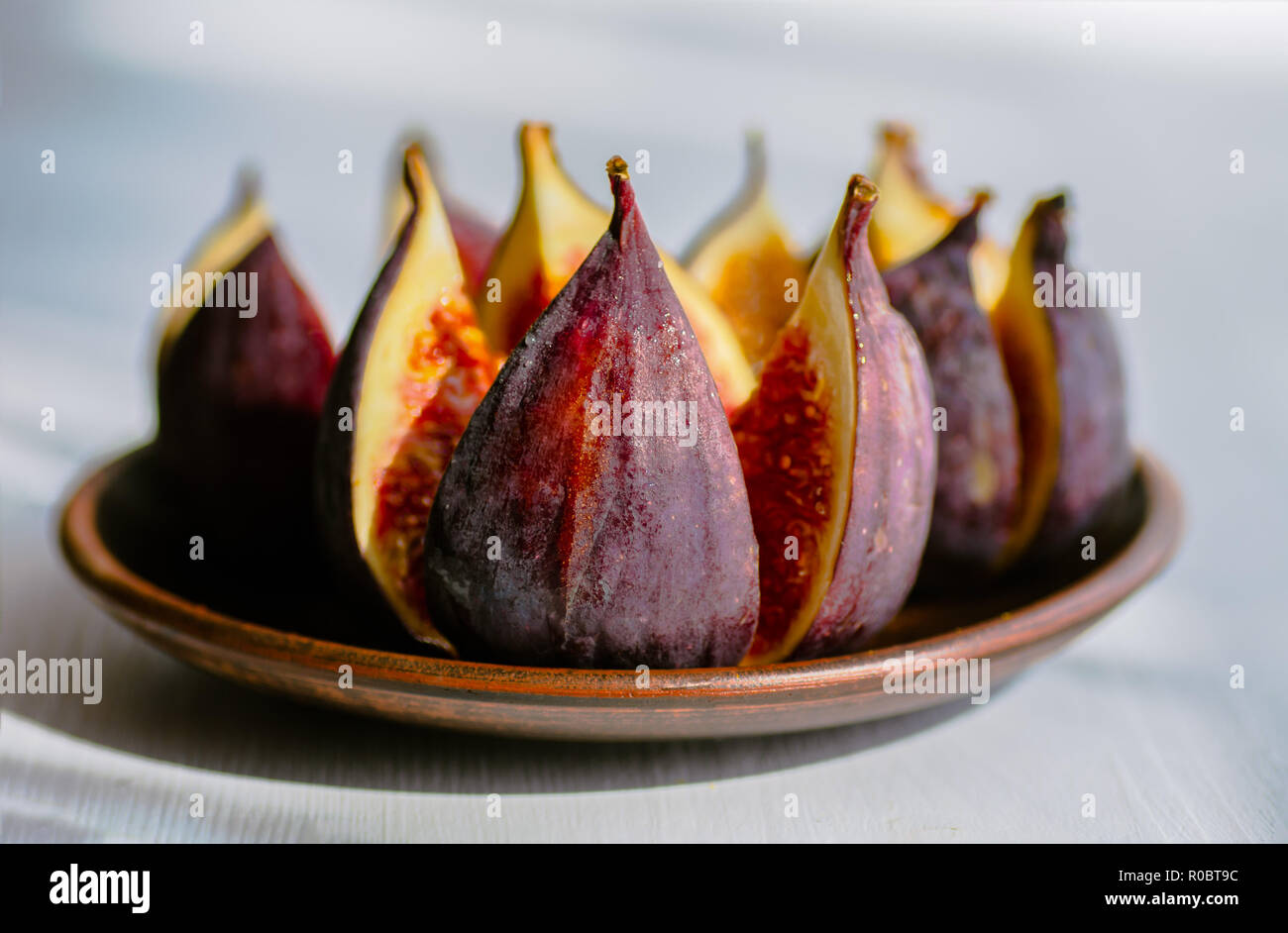 Figues mûres dans une assiette sur un fond de bois blanc. Traitement de l'anémie. Potassium pour le cœur. Banque D'Images