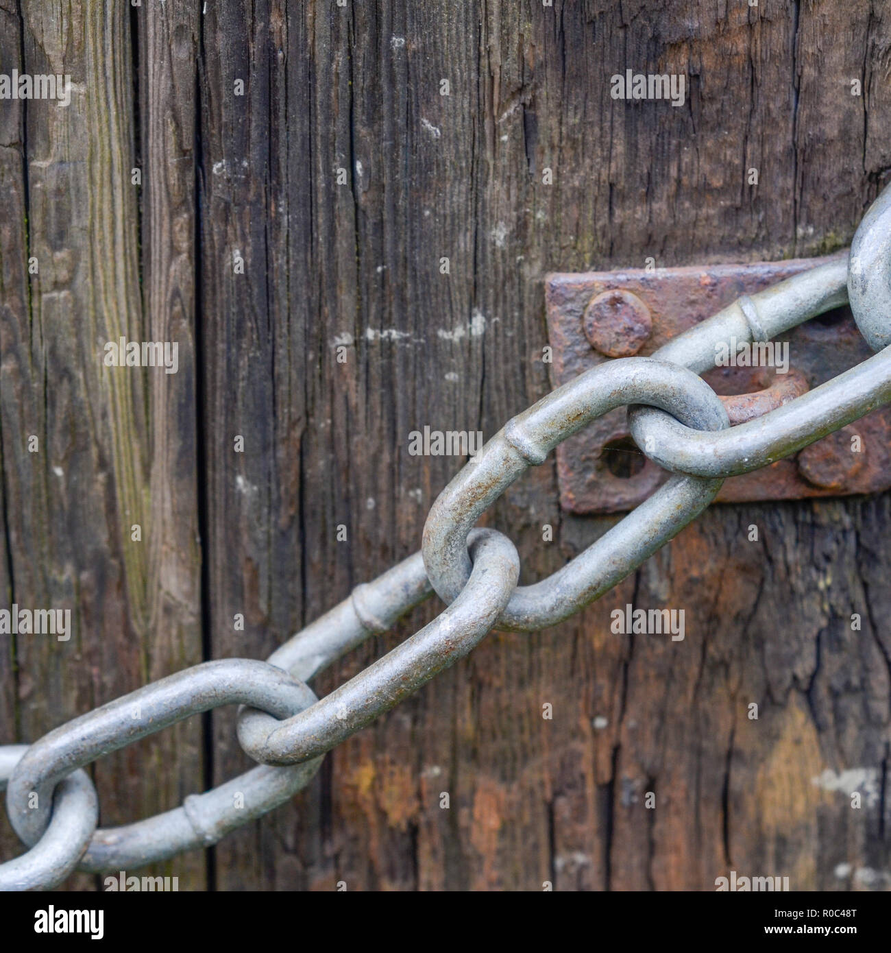 Section de chaîne de grande taille autour d'un montant de porte de ferme. Métaphore « enchaînée à votre travail », évier de cuisine, etc Banque D'Images