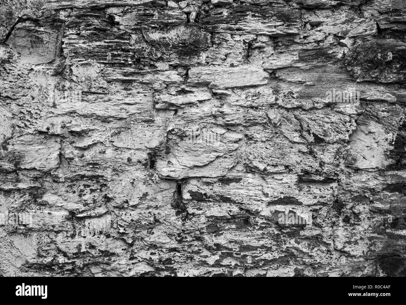 La texture du mur de pierre en ruine (converti en monochrome). Banque D'Images